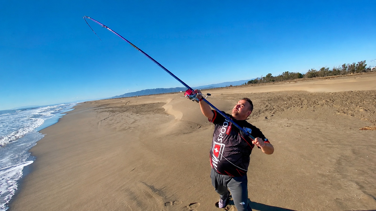 Roberto lanzando la caña de surfcasting en la playa